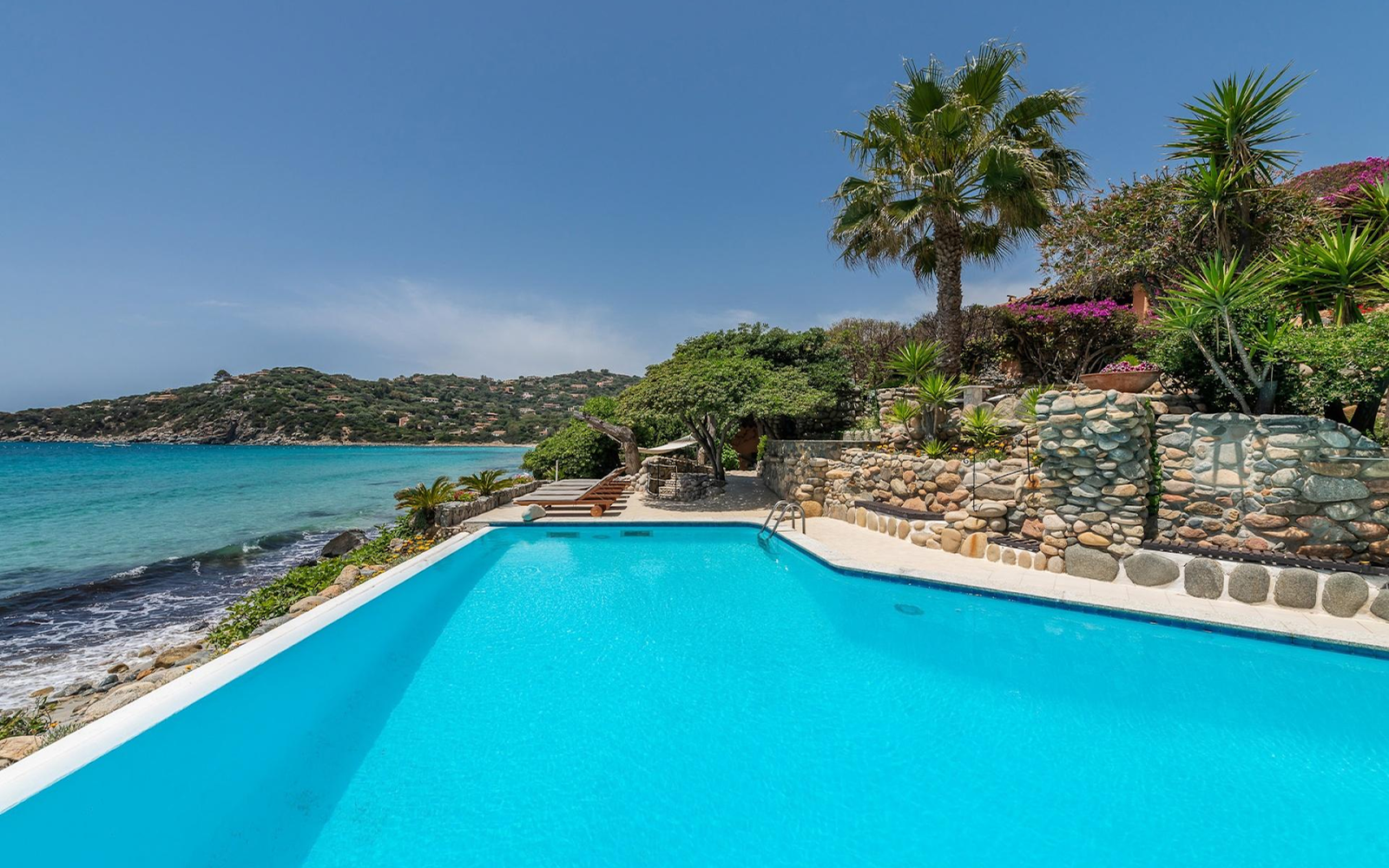 Oceanfront infinity pool with turquoise Sardinian waters