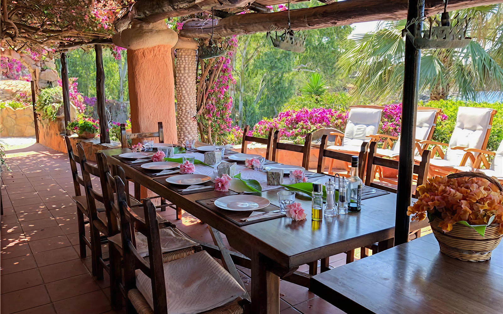 Al-fresco dining table beneath flowering bougainvillea